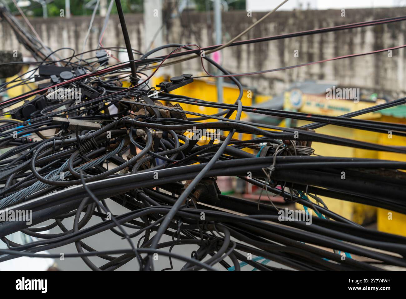 Guardando dall'alto, si trova al primo piano e all'angolo della strada. Molti cavi metallici complessi e frastagliati che corrono lungo le strade laterali in un sobborgo della Foto Stock