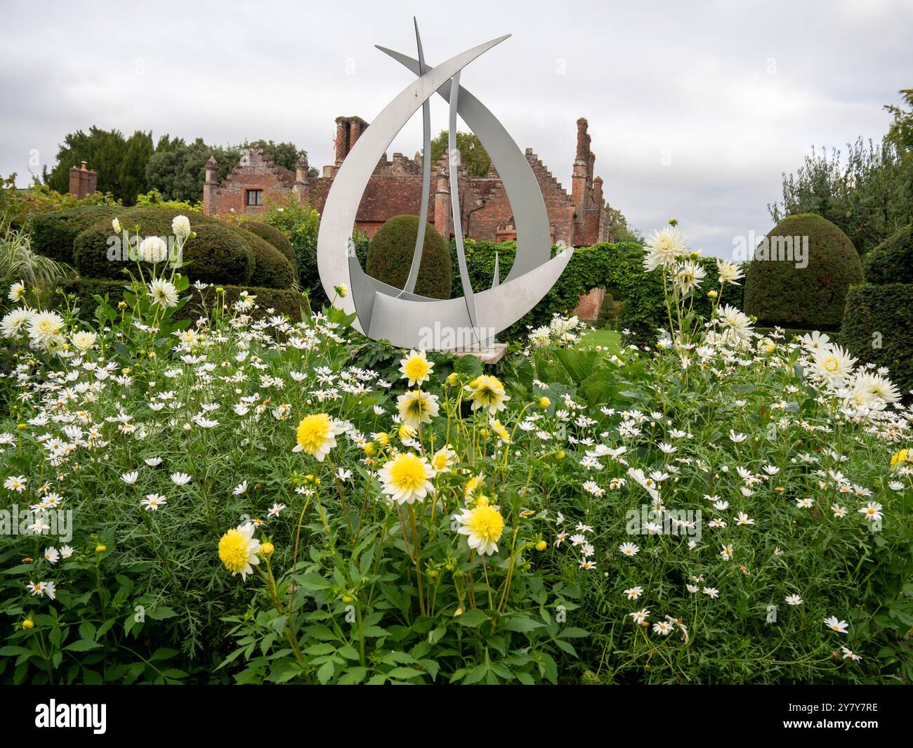 Chenies Manor House a settembre; Dahlia 'Freya's Paso Doble', Marguerite bianche, dahlias bianche nel giardino topiario con cornice scultorea curva. Foto Stock