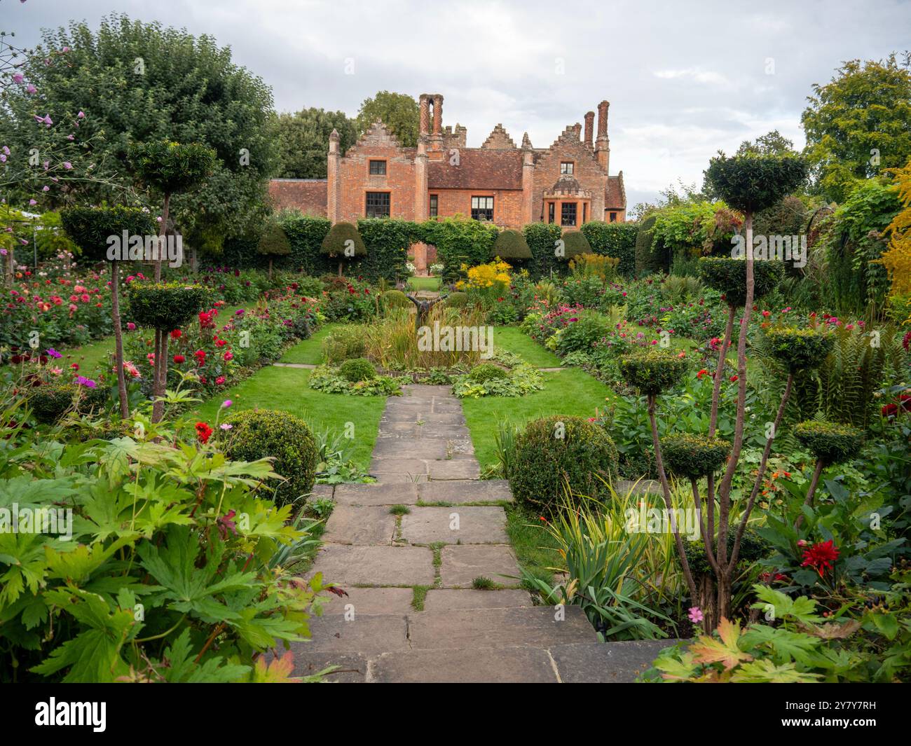 Chenies Manor Sunken Garden a settembre di fronte alla casa. I sentieri asfaltati e erbosi conducono all'occhio con le ricche varietà di dahlia ai confini. Foto Stock
