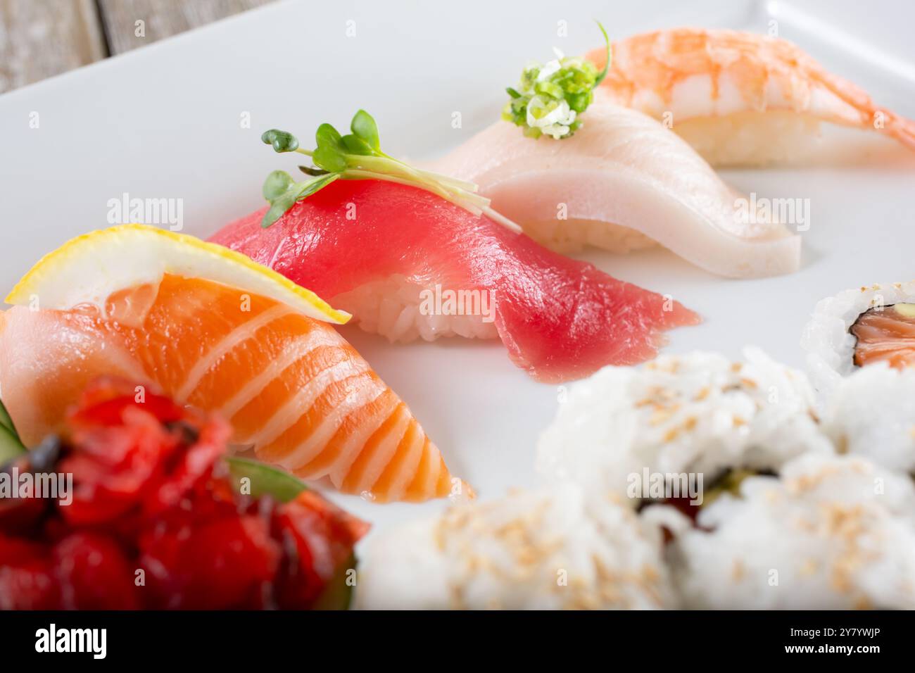 Vista ravvicinata di un piatto con nigiri, come salmone, tonno, coda gialla e gamberi. Foto Stock