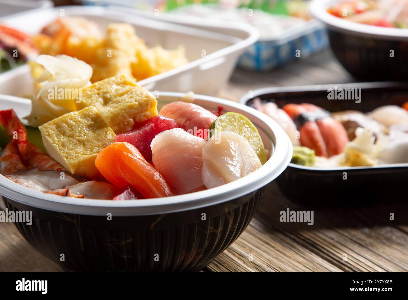 Una vista di diverse ciotole e piatti di pezzi di sushi. Foto Stock