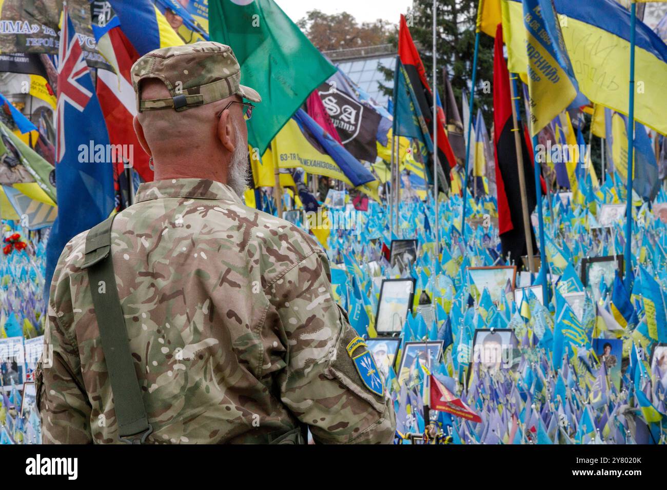 KIEV, UCRAINA - 1 SETTEMBRE 2024 - Un militare si trova al "prato della memoria nazionale" coperto di bandiere con i nomi degli eroi caduti durante un minuto di silenzio a livello nazionale in memoria dei soldati morti nel giorno dei difensori dell'Ucraina, in piazza Maidan Nezalezhnosti, Kiev, capitale dell'Ucraina Foto Stock
