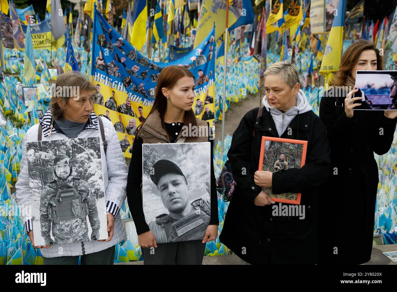 KIEV, UCRAINA - 01 SETTEMBRE 2024 - persone hanno un cartello sul "prato della memoria nazionale" coperto di bandiere con i nomi degli eroi caduti durante un minuto di silenzio a livello nazionale in memoria dei soldati morti nel giorno dei difensori dell'Ucraina, in piazza Maidan Nezalezhnosti, Kiev, capitale dell'Ucraina Foto Stock