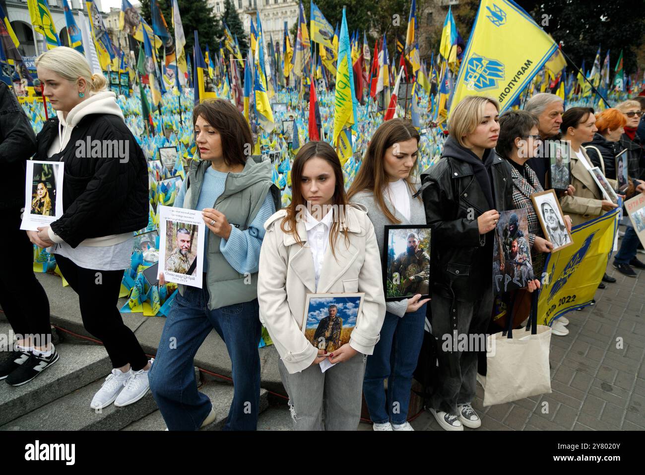 KIEV, UCRAINA - 01 SETTEMBRE 2024 - persone hanno un cartello sul "prato della memoria nazionale" coperto di bandiere con i nomi degli eroi caduti durante un minuto di silenzio a livello nazionale in memoria dei soldati morti nel giorno dei difensori dell'Ucraina, in piazza Maidan Nezalezhnosti, Kiev, capitale dell'Ucraina Foto Stock