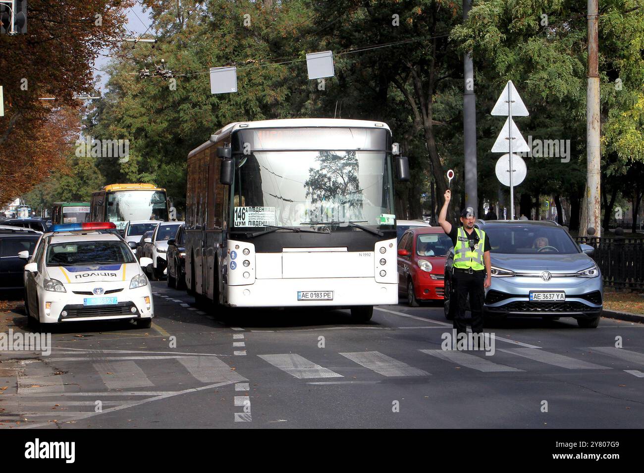 Non esclusiva: DNIPRO, UCRAINA - 01 OTTOBRE 2024 - Un poliziotto blocca il traffico durante un minuto di silenzio a livello nazionale in memoria dei soldati caduti Foto Stock