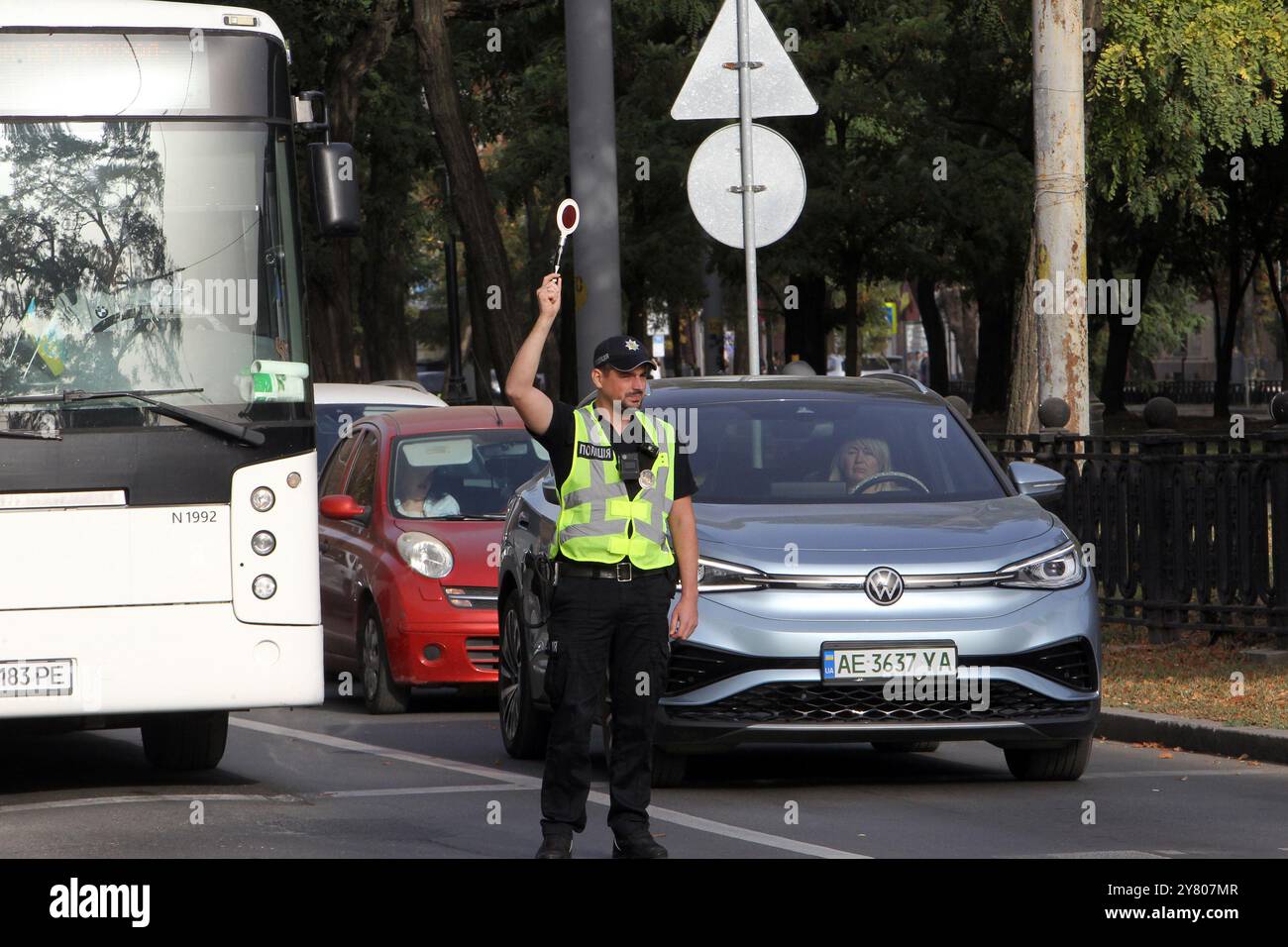Non esclusiva: DNIPRO, UCRAINA - 01 OTTOBRE 2024 - Un poliziotto blocca il traffico durante un minuto di silenzio a livello nazionale in memoria dei soldati caduti Foto Stock