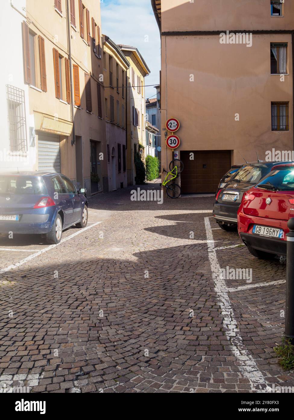 Mantova, Italia 30 settembre 2024 Una bicicletta verde lime si appoggia contro un muro sotto un cartello stradale con limite di altezza e limite di velocità in una città italiana Foto Stock