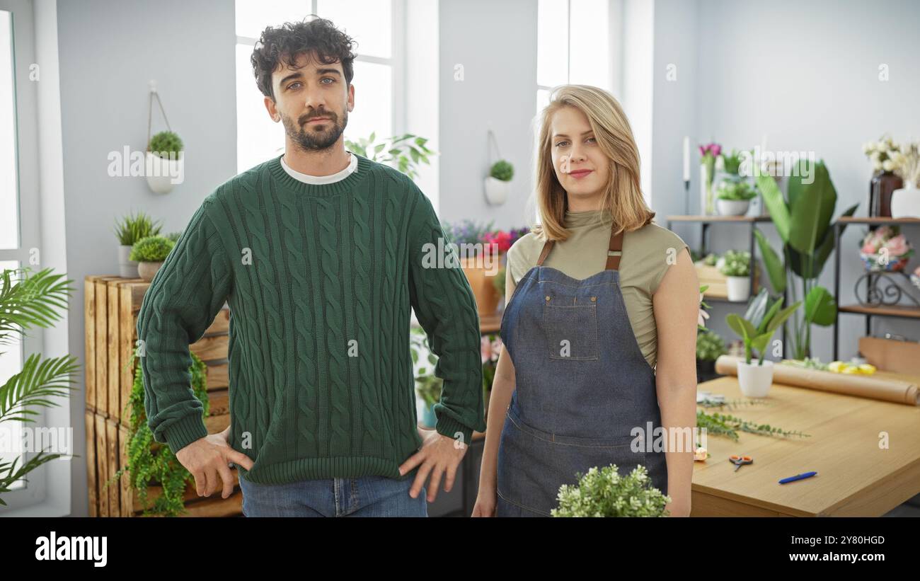 Uomo e donna in piedi insieme in un negozio di fiori circondato da varie piante e composizioni floreali. Foto Stock