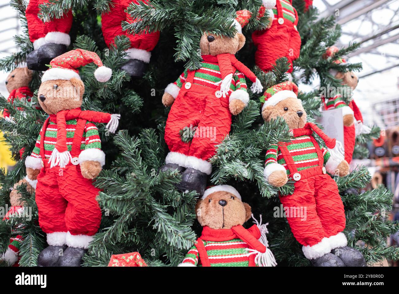 Adorabili orsetti di peluche che indossano un cappello di Babbo Natale appeso su un albero di Natale. Concetto di festività e festeggiamenti. Felice anno nuovo e buon Natale cartolina. FES Foto Stock