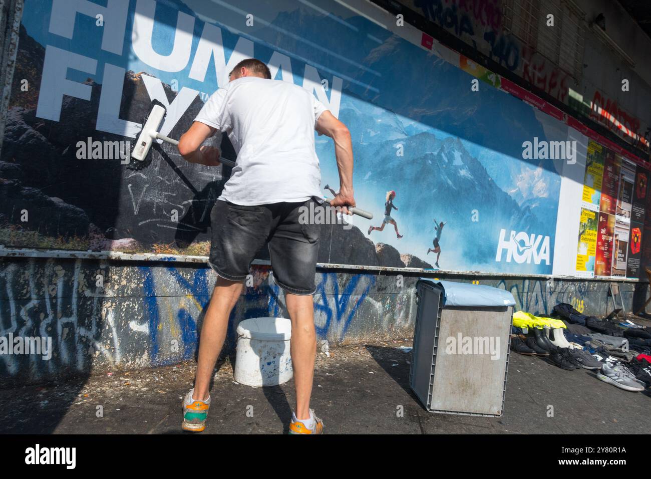 Un uomo prepara un poster Kottbusser Tor - Kotti City Town District Kreuzberg Berlino Germania Europa Foto Stock