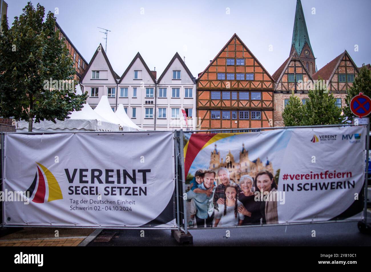 Schwerin, Germania. 2 ottobre 2024. Le aree espositive nel centro della città sono circondate da recinzioni e manifesti con il motto "salpa unita" prima dell'inizio delle celebrazioni per la giornata dell'unità tedesca. Oltre allo stato ospitante, saranno presenti anche tutti gli altri stati federali, il Bundestag, il Bundesrat, i ministeri, le istituzioni e le associazioni. Nell'ambito della presidenza del Bundesrat, Schwerin ospita le celebrazioni centrali per la giornata dell'unità tedesca con il motto "Setting Sail united". Crediti: Jens Büttner/dpa/Alamy Live News Foto Stock