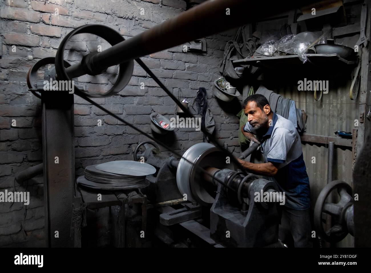 Dacca, Dacca, Bangladesh. 2 ottobre 2024. Nel Kamrangirchar di Dacca, le fabbriche di utensili in alluminio operano in condizioni pericolose. I lavoratori, privi di dispositivi di protezione, sono rivestiti di polvere di alluminio nociva poiché maneggiano macchinari pesanti in un ambiente ristretto e scarsamente illuminato. Esposti alla luce minima dall'alto, affrontano gravi problemi di vista insieme a problemi di salute. Intrappolati in posti di lavoro a basso costo, questi lavoratori devono affrontare uno sfruttamento continuo, intrappolati in un ciclo di povertà e lavoro pericoloso che compromette il loro benessere. (Credit Image: © Joy Saha/ZUMA Press Wire) SOLO PER USO EDITORIALE! Non per Commerci Foto Stock