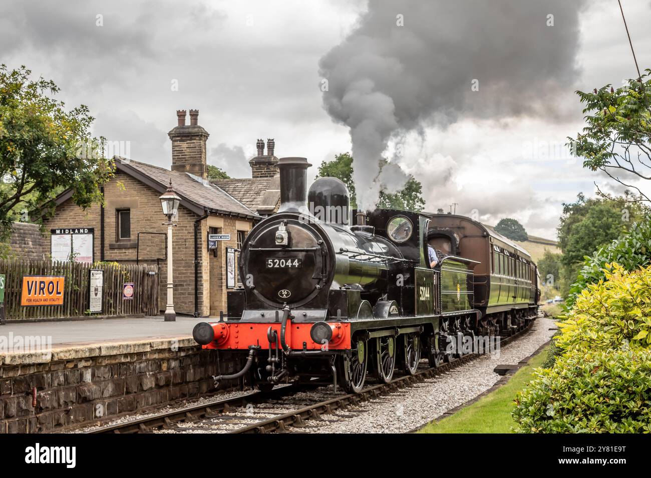 BR 'Class 25' 0-6-0 No. 52044 arriva a Oakworth sulla Keighley and Worth Valley Railway, Yorkshire, Inghilterra, Regno Unito Foto Stock