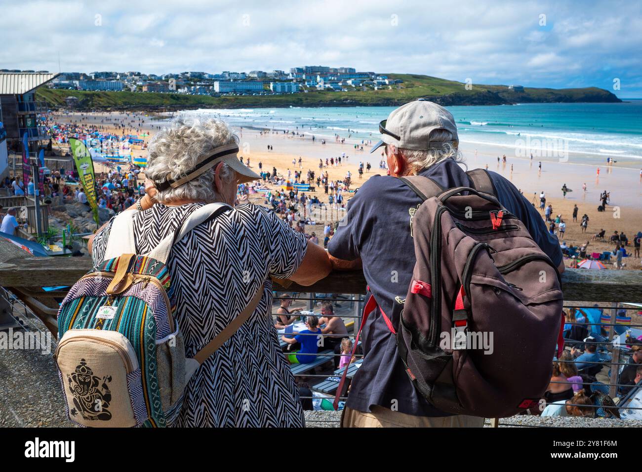 Turisti maturi che si affacciano su un'affollata spiaggia di Fistral a Newquay, in Cornovaglia, nel Regno Unito. Foto Stock