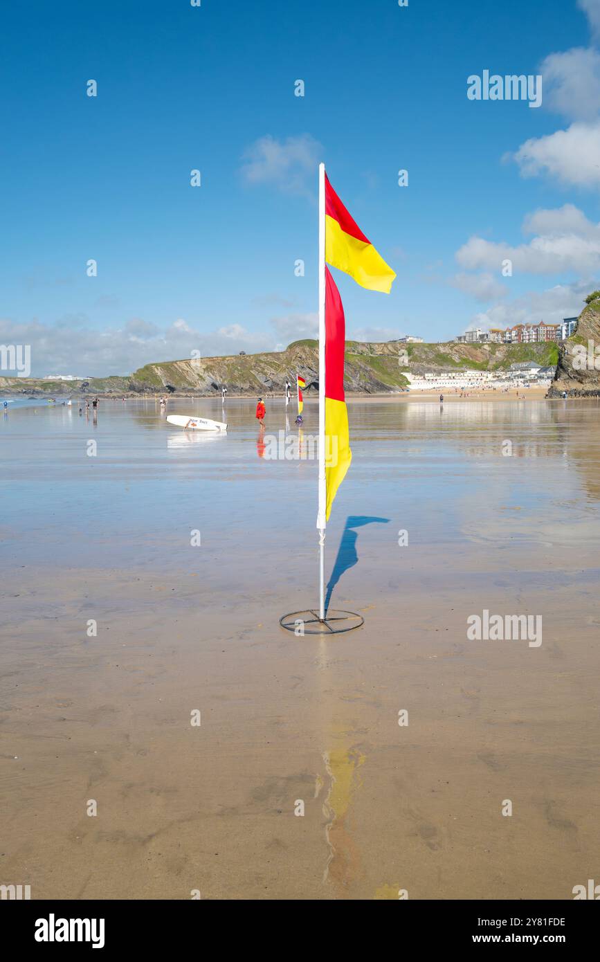 Bandiere rosse e gialle che indicano l'area pattugliata dai bagnini RNLI sulla GT Great Western Beach a Newquay in Cornovaglia nel Regno Unito. Foto Stock