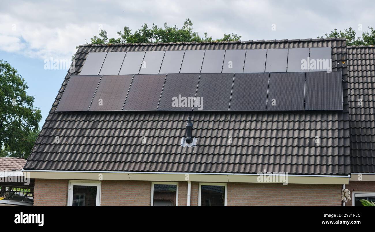pannelli solari di due dimensioni installati sul tetto di una casa residenziale, che mostrano il progresso dell'energia rinnovabile nel corso degli anni nella vita moderna. Foto Stock