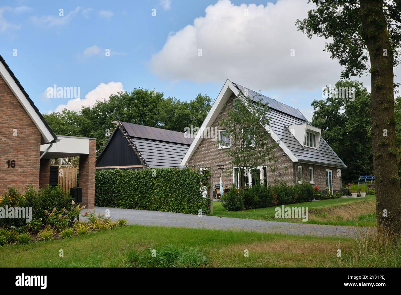 pannelli solari installati sul tetto di una nuova casa residenziale e garage, che mostrano l'integrazione dell'energia rinnovabile nella vita moderna. Costruzione di ga Foto Stock