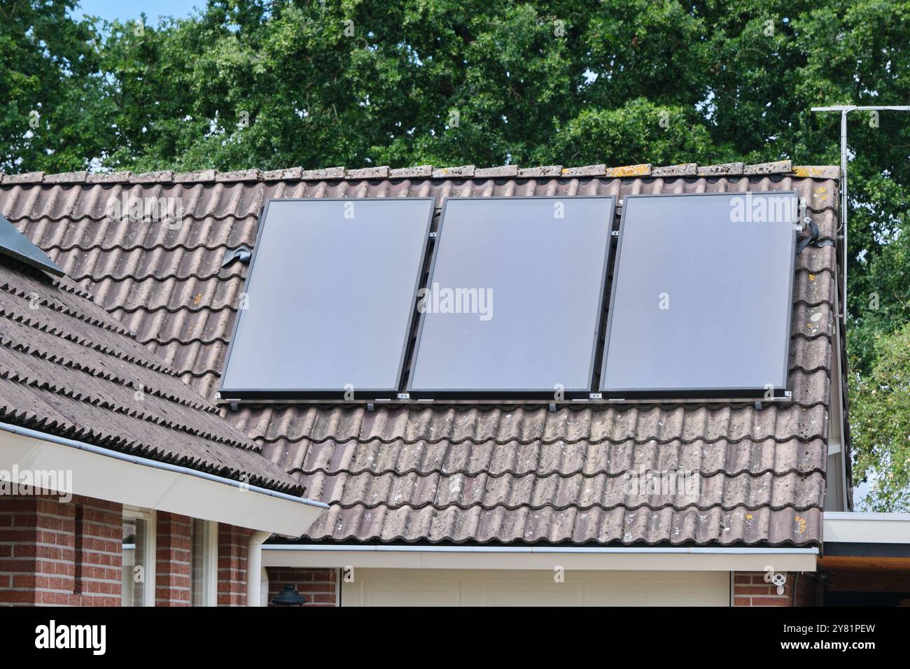 pannelli solari piatti installati sul tetto di una casa residenziale, che mostrano l'integrazione dell'energia rinnovabile nella vita moderna. Una dimostrazione Foto Stock