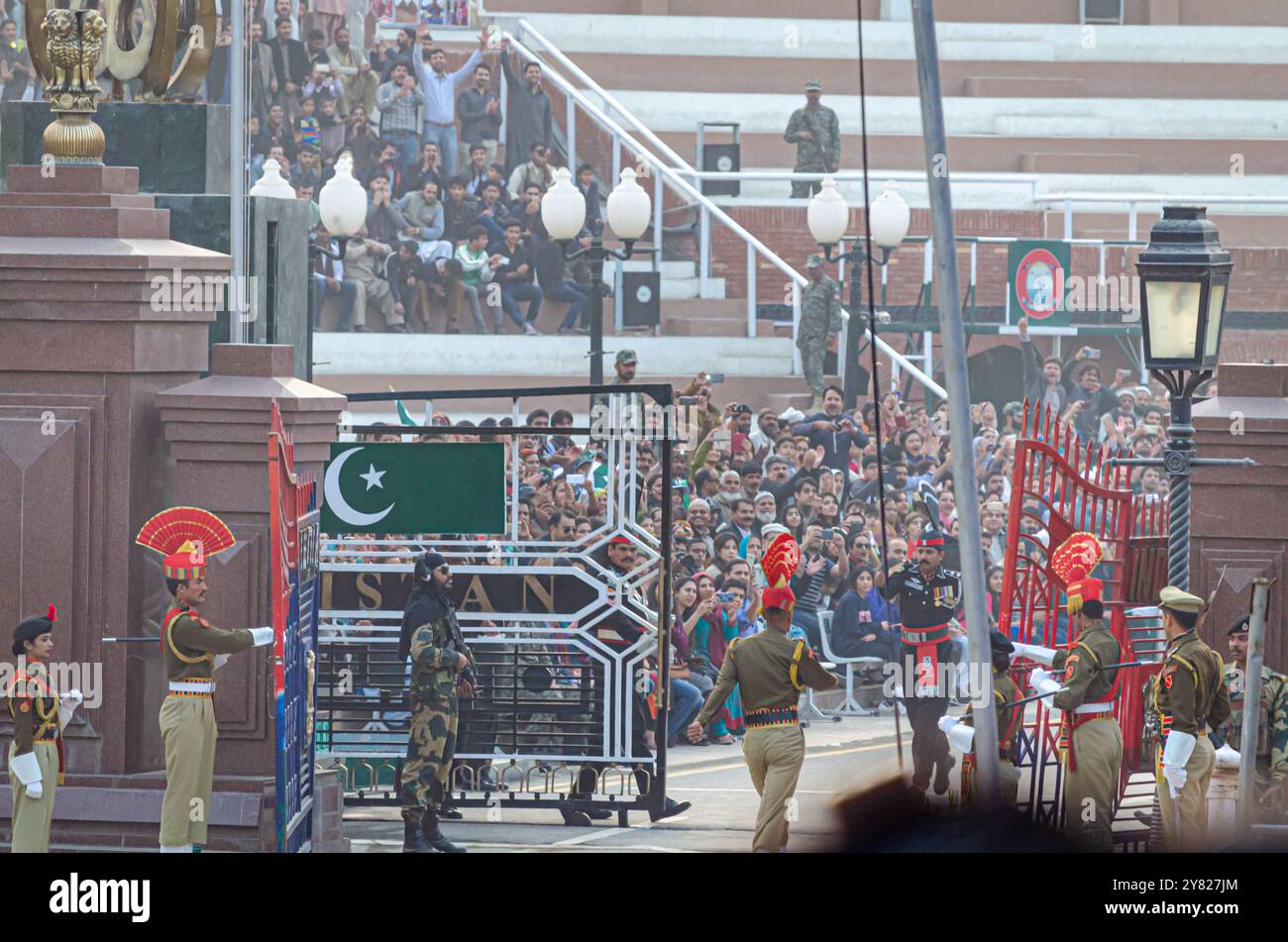 Le forze di sicurezza di frontiera sfilano durante la cerimonia di abbassamento della bandiera del confine Attari-Wagah Foto Stock