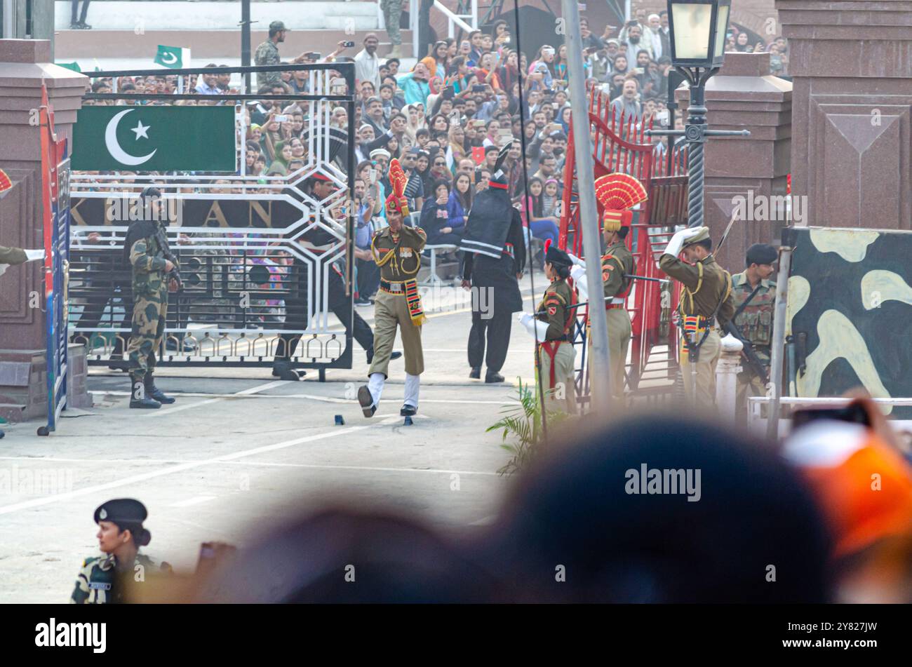 Le forze di sicurezza di frontiera sfilano durante la cerimonia di abbassamento della bandiera del confine Attari-Wagah Foto Stock