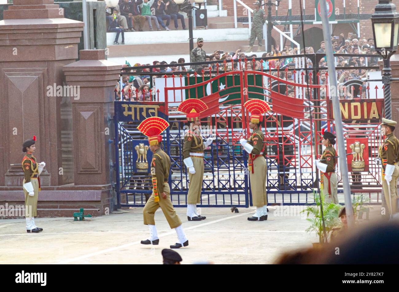 Le forze di sicurezza di frontiera sfilano durante la cerimonia di abbassamento della bandiera del confine Attari-Wagah Foto Stock