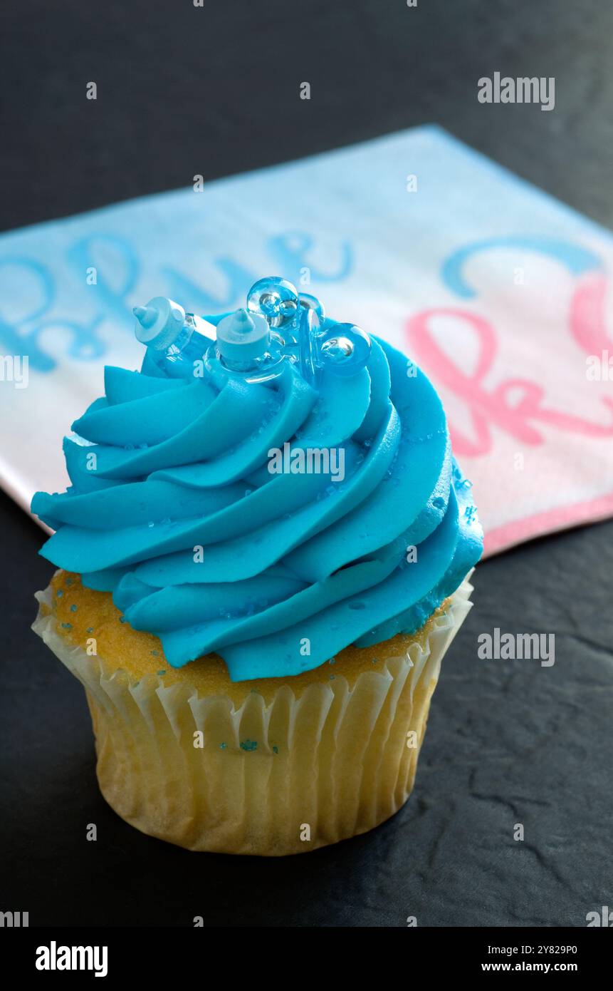 Vista ravvicinata della muffin alla vaniglia con glassa blu per doccia per bambini verticale Foto Stock