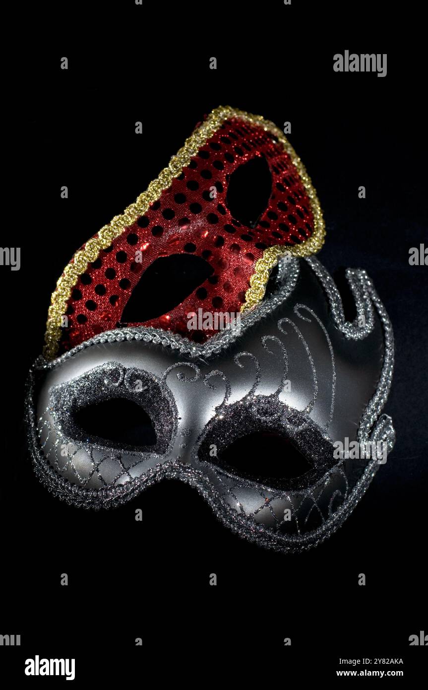 Maschere di Carnevale argento e rosso su sfondo scuro verticale Foto Stock