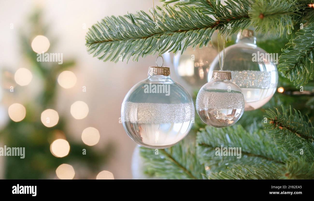 Baule natalizie in vetro appese su rami verdi di pino con luci festive, splendenti ornamenti natalizi con sfondo bokeh, elegante minimalista Foto Stock