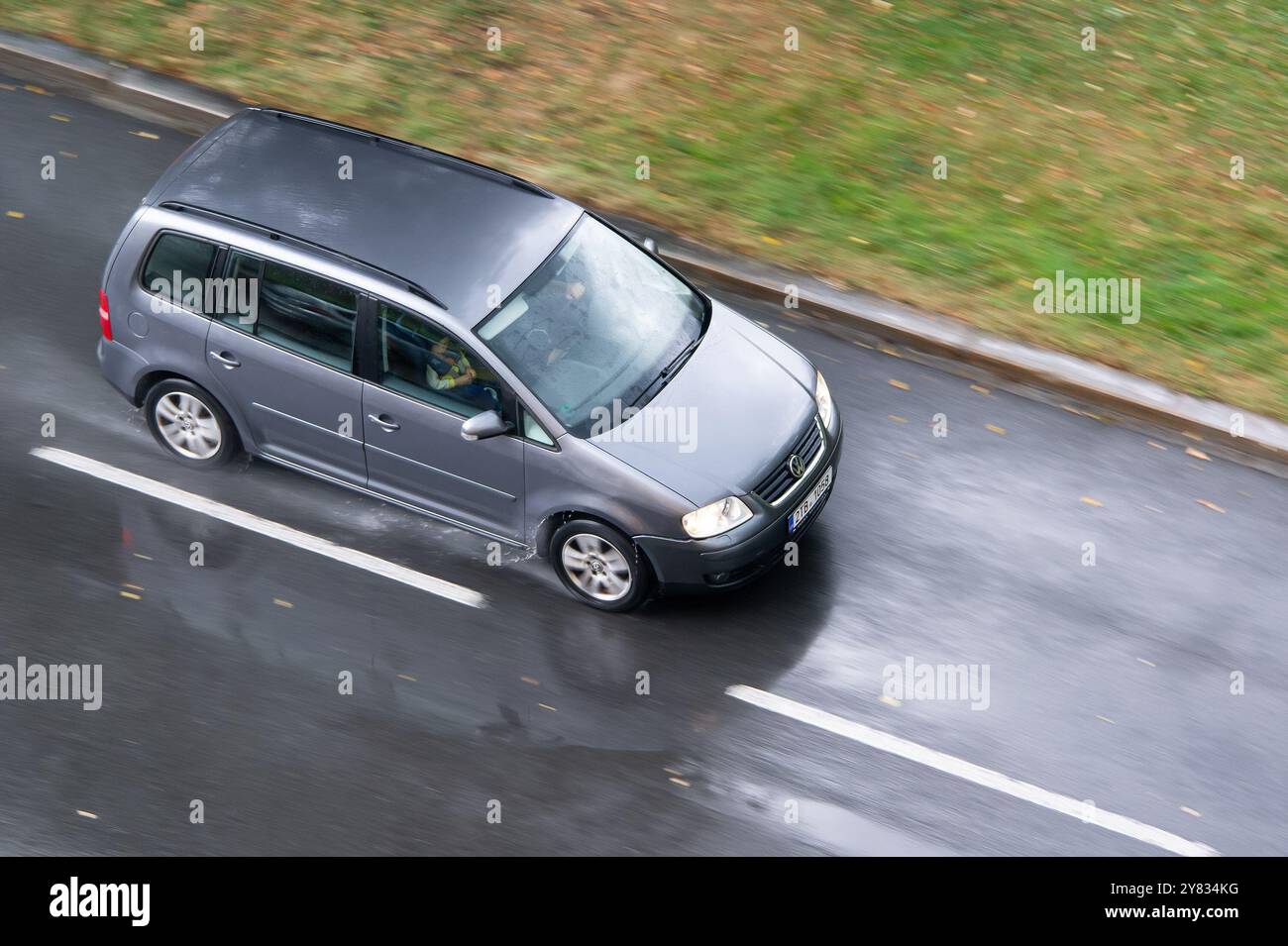 OSTRAVA, CECHIA - 8 AGOSTO 2024: Volkswagen Touran MPV, effetto di sfocatura del movimento in caso di pioggia Foto Stock