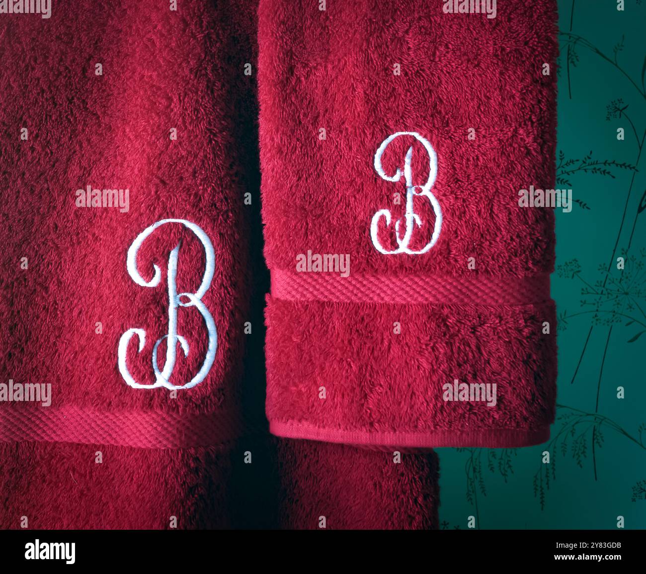 Asciugamani da bagno rossi monogrammati. B maiuscola corsiva cotone, dimensioni corpo e viso. Foto Stock