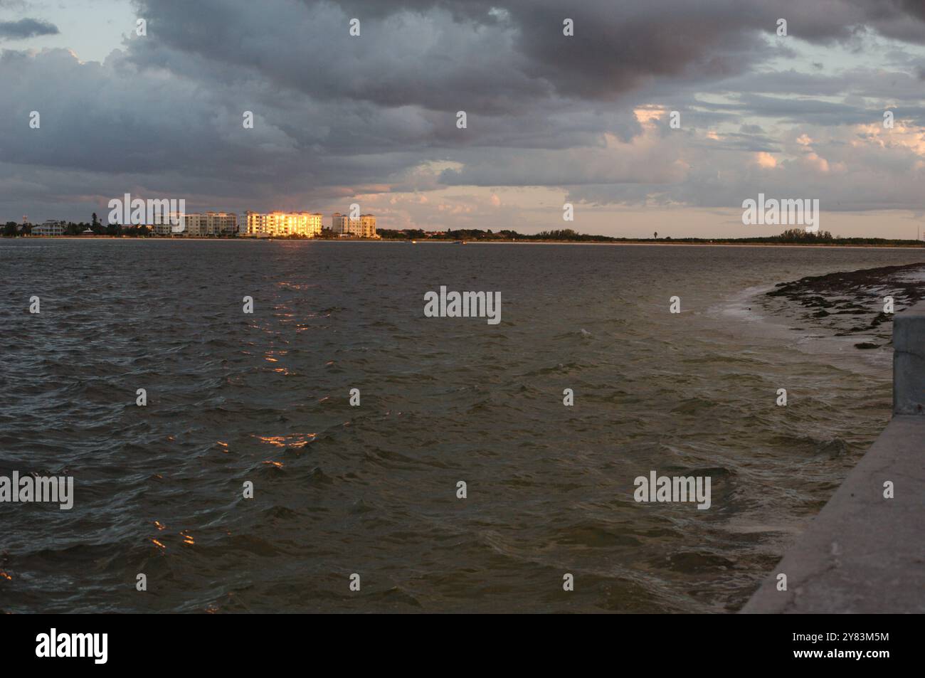 Ampia vista dell'ambiente vicino al tramonto con luce solare e ombra. A St. Pete Beach, Florida, che guarda al canale Pass-a-Grille. Tempesta che si avvicina in ritardo nella D. Foto Stock