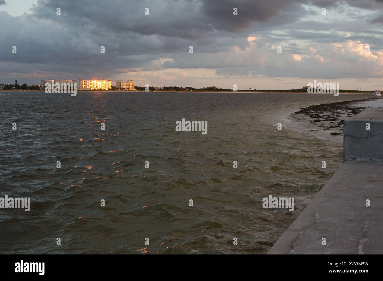 Ampia vista dell'ambiente vicino al tramonto con luce solare e ombra. A St. Pete Beach, Florida, che guarda al canale Pass-a-Grille. Tempesta che si avvicina in ritardo nella D. Foto Stock