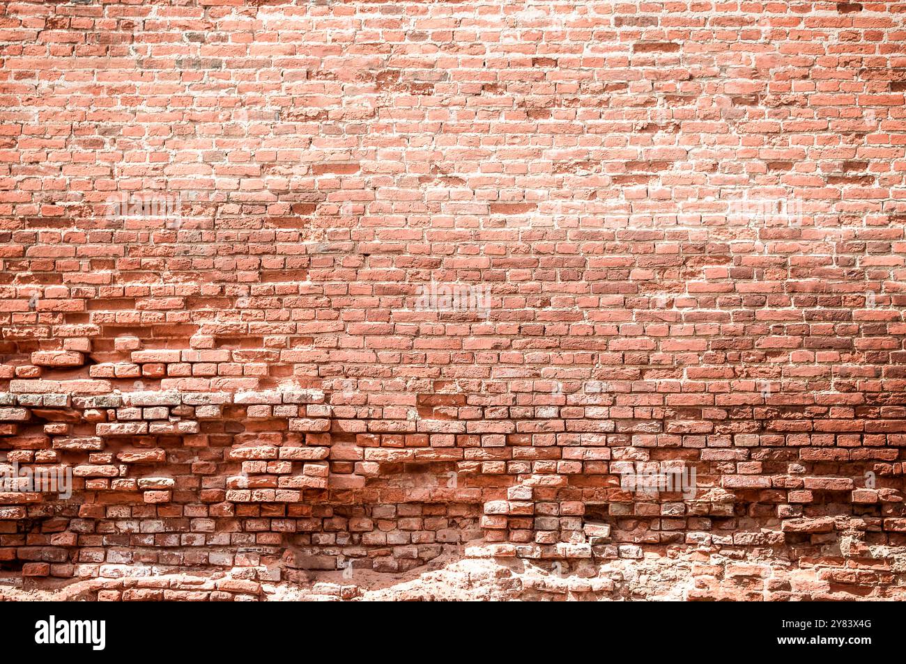 Un muro di mattoni è una struttura robusta fatta di mattoni e Malta. Fornisce privacy, sicurezza e fascino estetico agli edifici. durata e tempi Foto Stock