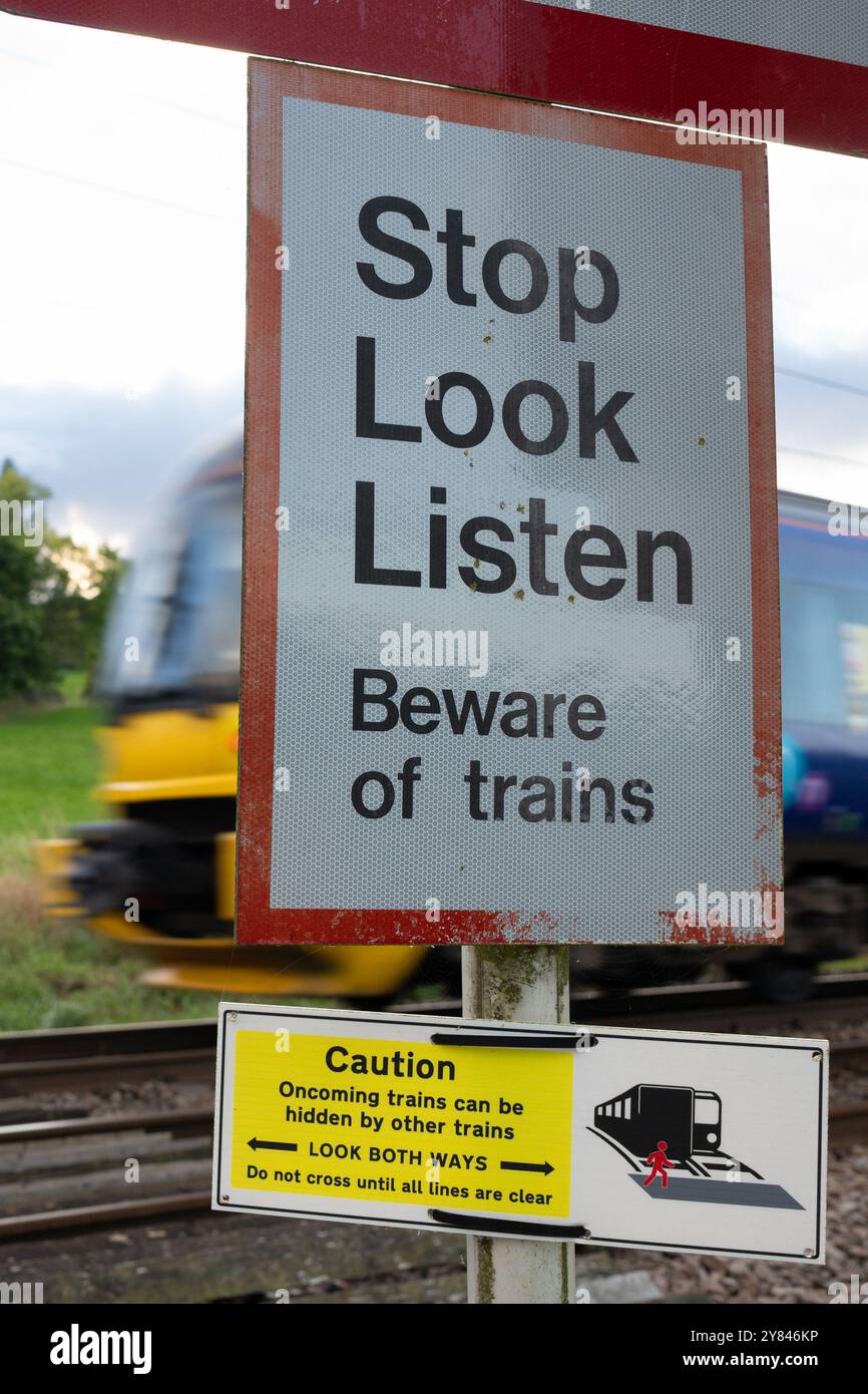 Treno Northern Trains Passing Stop Look Listen cartello all'incrocio Pedistrian, Burley a Wharfedale, Ilkley, Leeds, West Yorkshire Foto Stock