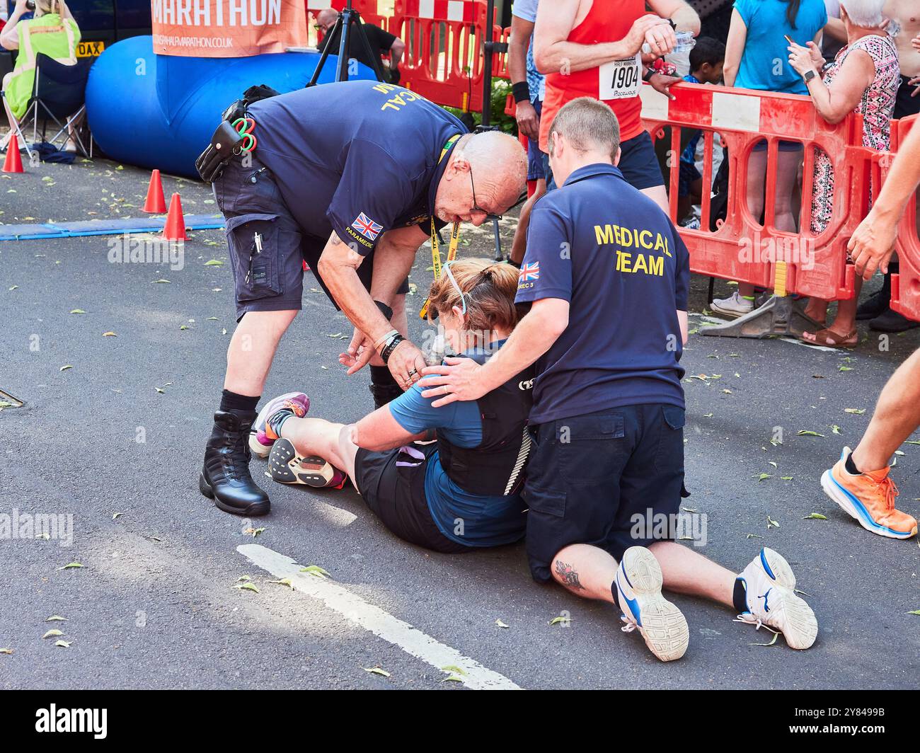 Mezza maratona crollata che riceve un trattamento paramedico al traguardo. Foto Stock