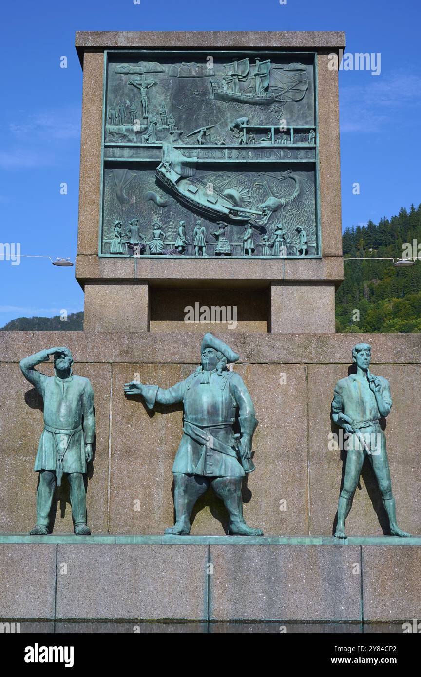 Il monumento Sjomannsmonumentet sul lato sud ai marinai mostra tre figure storiche, con un dettaglio sullo sfondo sotto un cielo blu, Bergen Foto Stock