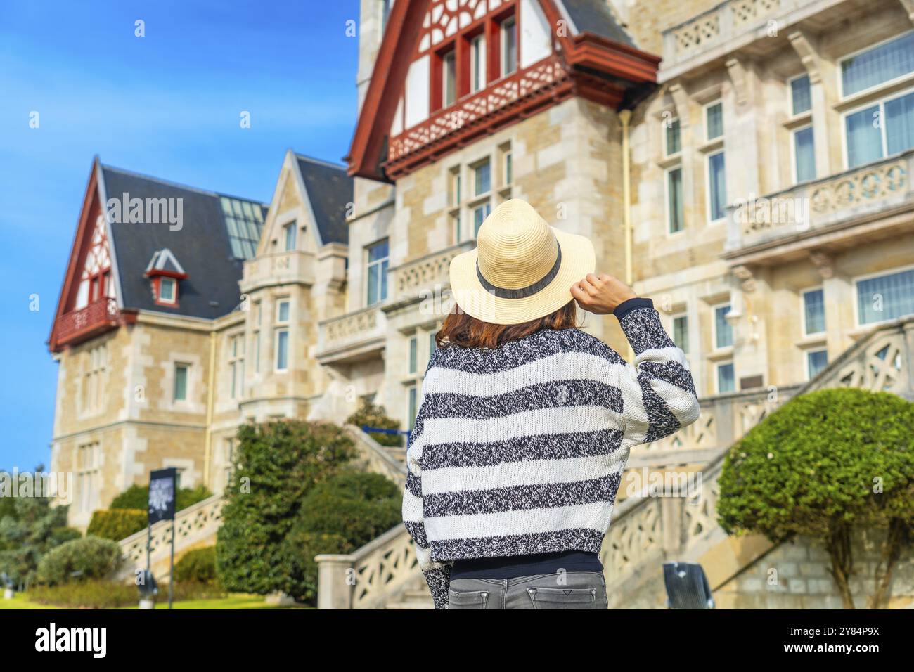 Una donna turistica il Palacio de la Magdalena accanto ai fiori in estate nella città di Santander Foto Stock