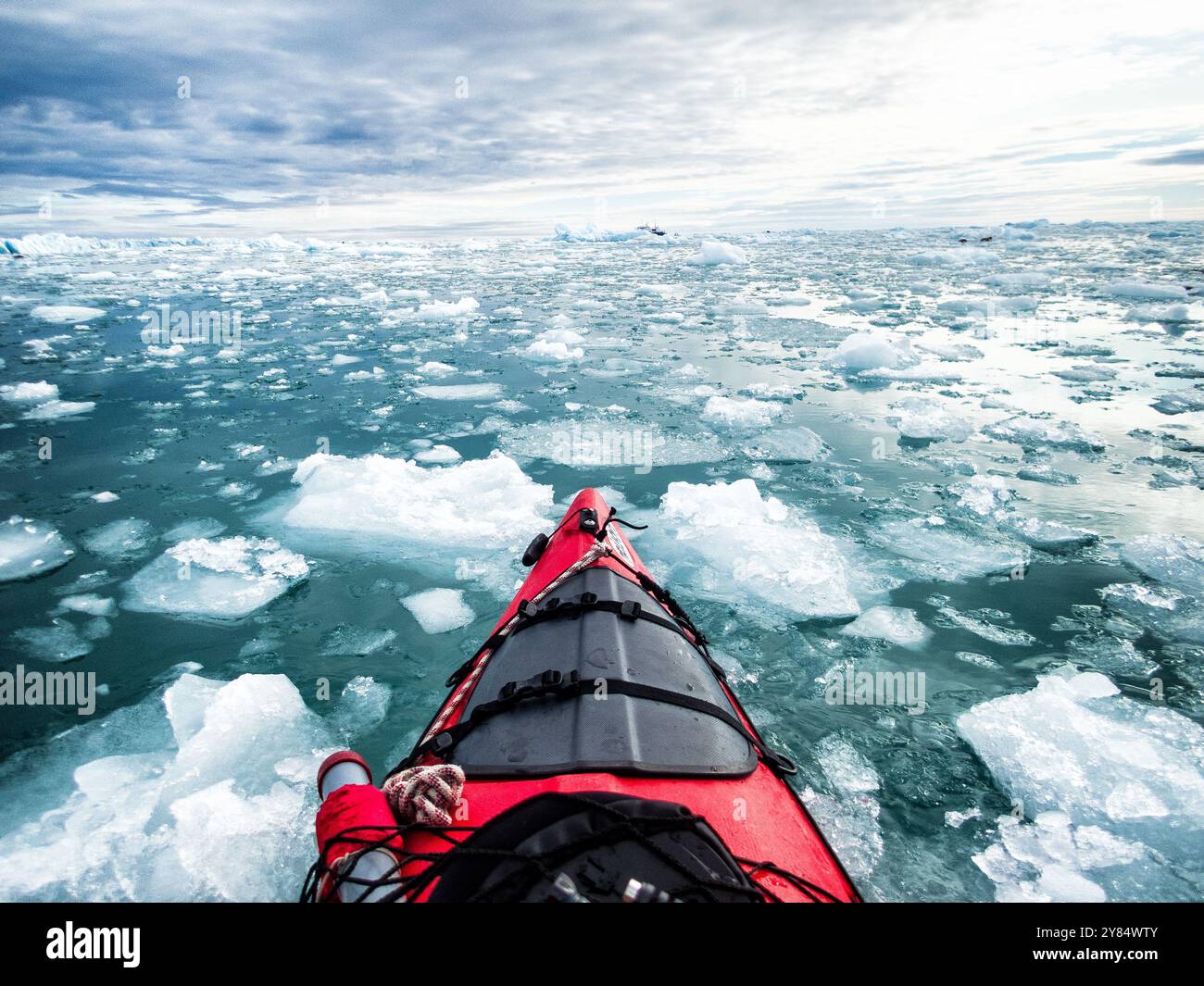 SVALBARD, Norvegia: Un punto di vista da un kayak marino che naviga attraverso il ghiaccio selvaggio nelle acque gelide che circondano le Svalbard, un arcipelago artico nel nord della Norvegia. I turisti avventurosi cercano sempre più esperienze di kayak in questa remota regione polare, consentendo incontri intimi con la natura selvaggia incontaminata dell'Artico e l'ecosistema marino unico. Le acque protette delle Svalbard offrono ai pagaiatori l'opportunità di esplorare un ambiente fragile che subisce rapidi cambiamenti dovuti al riscaldamento globale, con le temperature estive che ora consentono regolarmente spedizioni in kayak tra ic Foto Stock SVALBARD, Norvegia: Un punto di vista da un kayak marino che naviga attraverso il ghiaccio selvaggio nelle acque gelide che circondano le Svalbard, un arcipelago artico nel nord della Norvegia. I turisti avventurosi cercano sempre più esperienze di kayak in questa remota regione polare, consentendo incontri intimi con la natura selvaggia incontaminata dell'Artico e l'ecosistema marino unico. Le acque protette delle Svalbard offrono ai pagaiatori l'opportunità di esplorare un ambiente fragile che subisce rapidi cambiamenti dovuti al riscaldamento globale, con le temperature estive che ora consentono regolarmente spedizioni in kayak tra ic Foto Stock