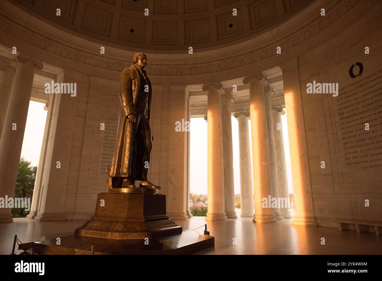 Jefferson Memorial Thomas Jefferson Statue Washington DC // WASHINGTON DC — la statua in bronzo di Thomas Jefferson dello scultore Rudulph Evans si trova nella rotonda del Jefferson Memorial. La statua di 19 piedi, installata nel 1947, cattura la luce del sole del mattino presto durante l'equinozio. L'ingresso rivolto a est del monumento consente alla luce diretta del sole di illuminare la figura in bronzo in determinati periodi dell'anno. Foto Stock