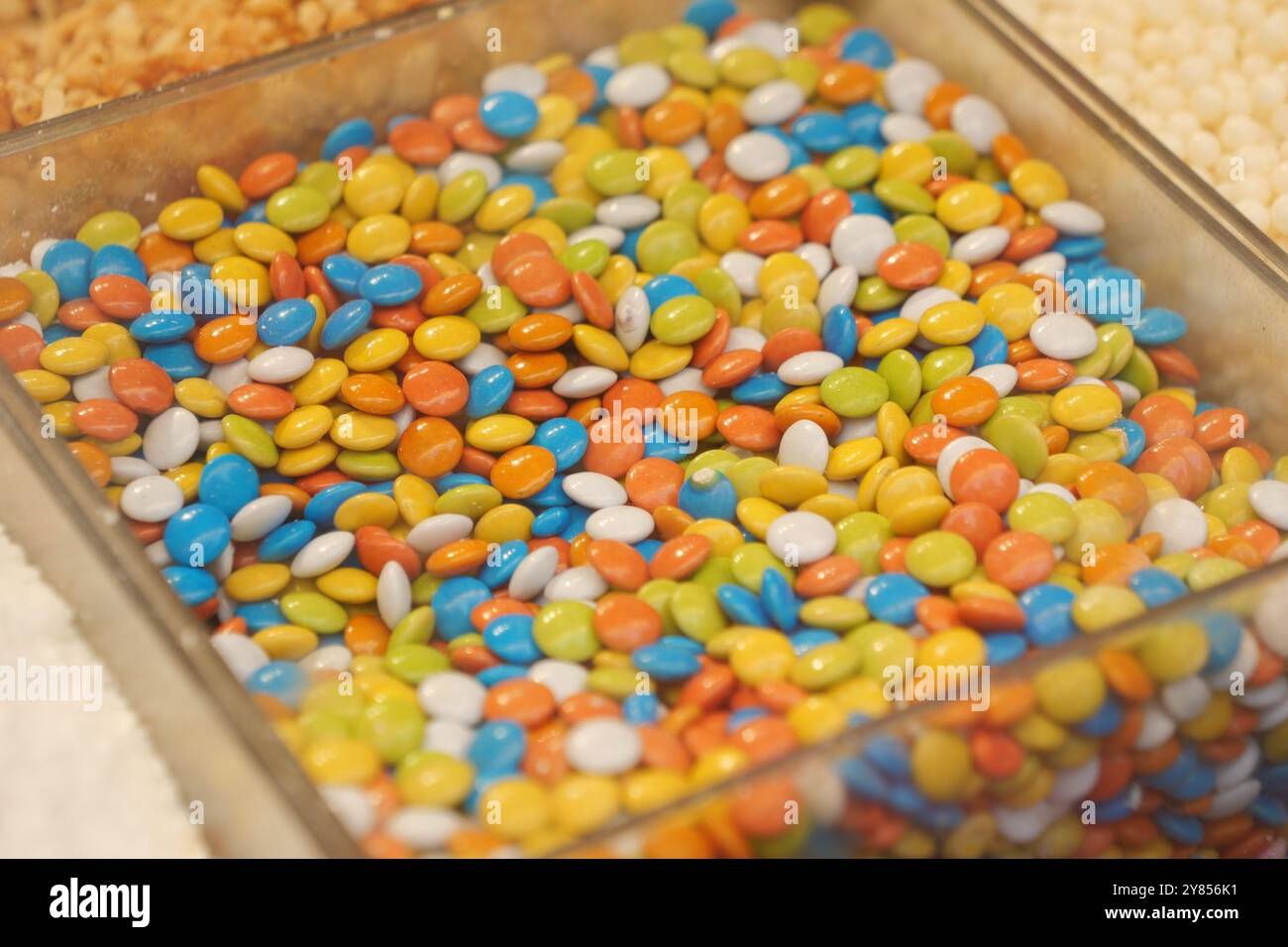 Un variegato e colorato assortimento di cioccolatini ricoperti di caramelle splendidamente disposti in un display Foto Stock