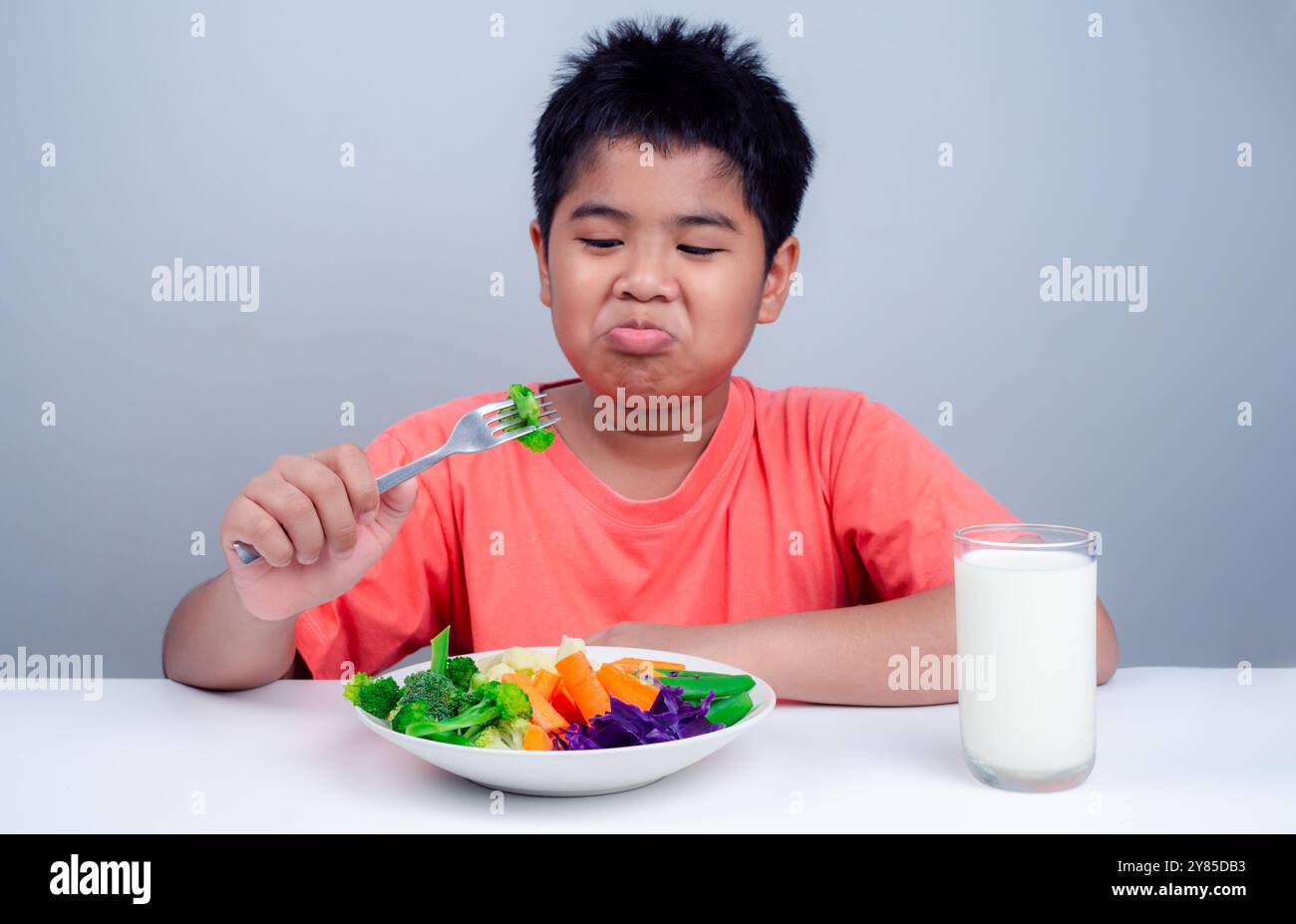 Ai bambini non piace mangiare verdure, il bambino carino rifiuta di mangiare verdure sane, nutrizione abitudini alimentari sane per bambini concetto, bambini Foto Stock