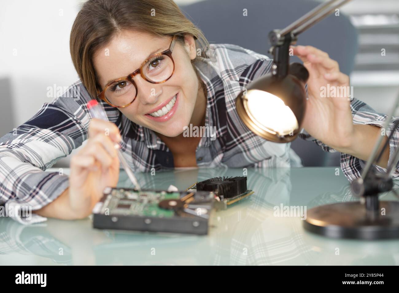 felice tecnico femmina che fissa il computer Foto Stock