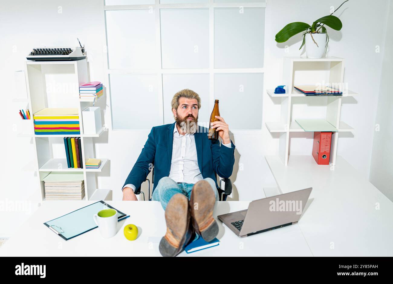 Triste lavoratore d'ufficio disperato sul licenziamento ingiusto perdere lavoro. Dopo un duro lavoro. Un uomo d'affari può tenere una bottiglia di birra. Foto Stock