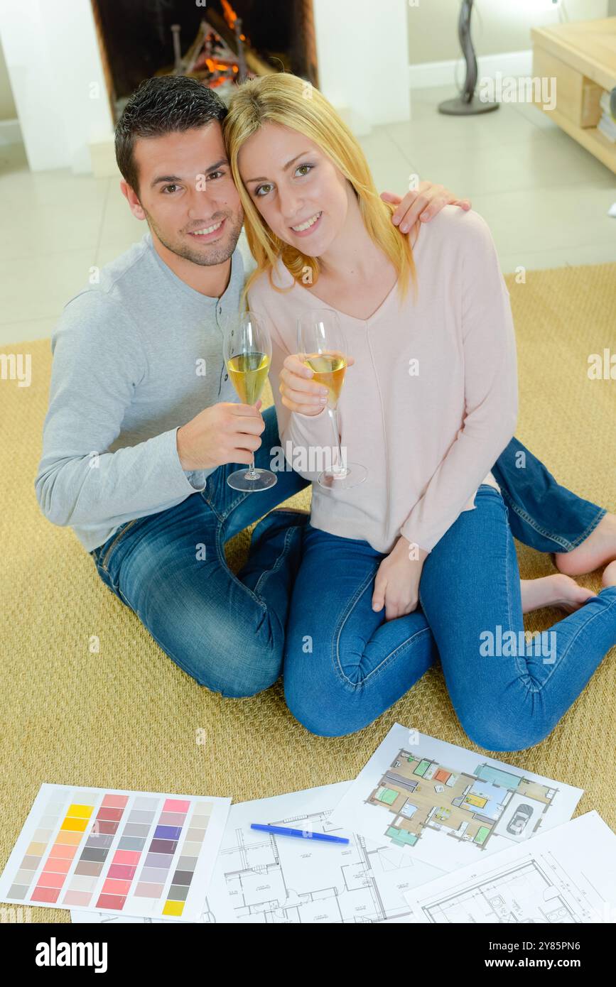 Coppia al piano con i piani, con il vino in mano Foto Stock