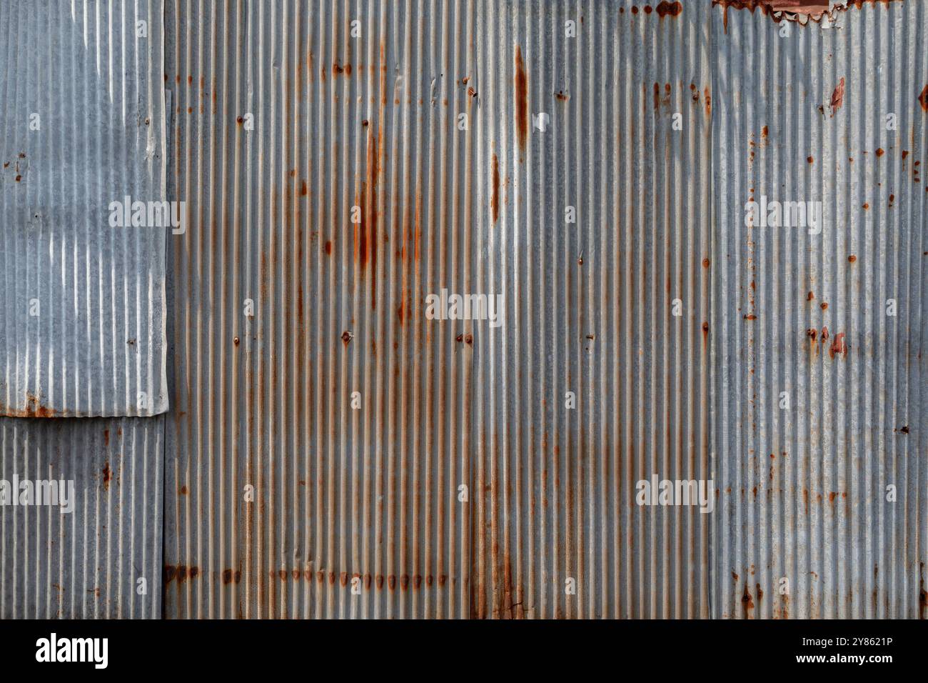 Vista frontale della parete del cantiere in ferro ondulato arrugginito e resistente agli agenti atmosferici. Sfondo ruggine ruggine ruggine ruvida full frame ad alta risoluzione. Foto Stock