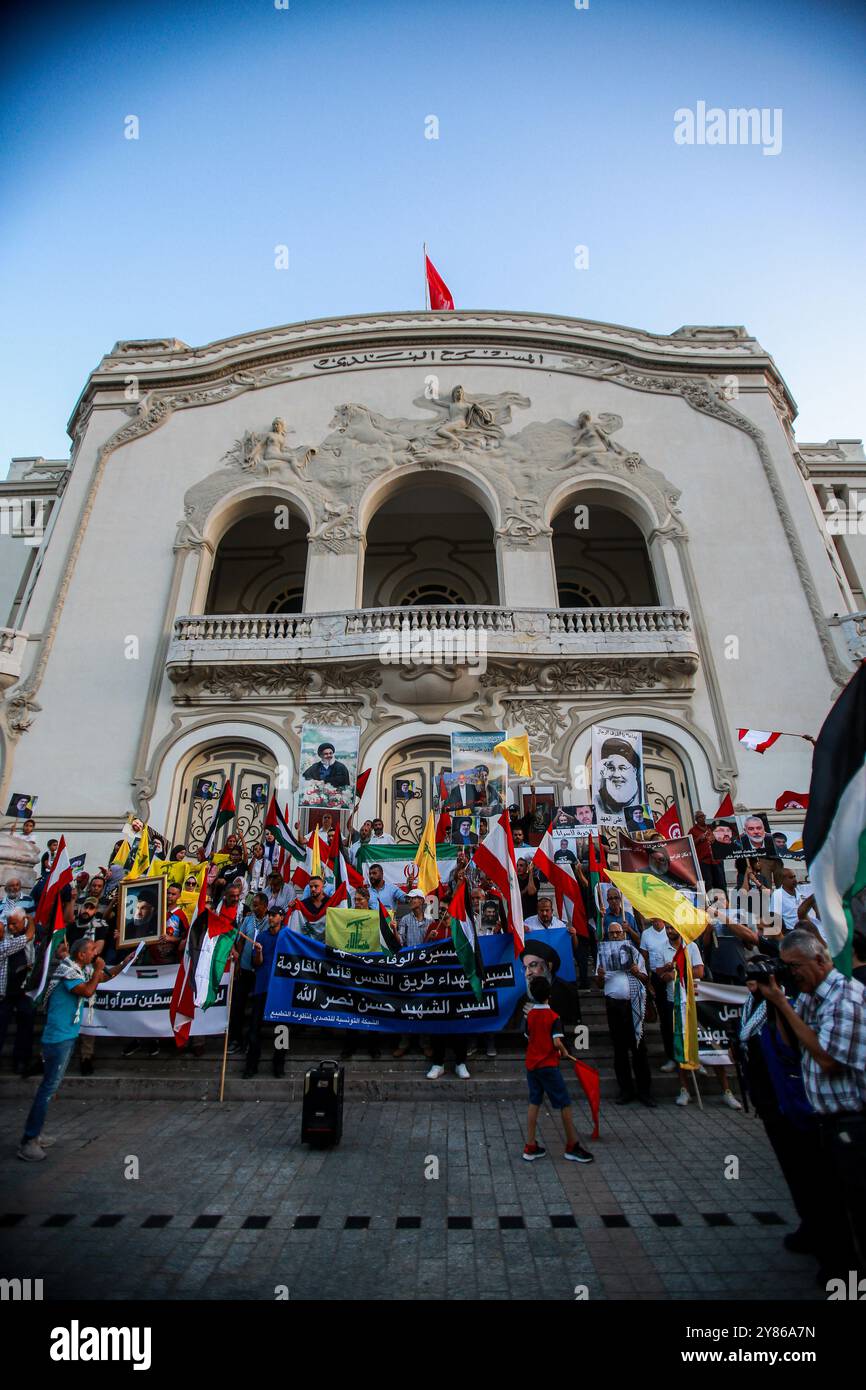 Tunisi, Tunisia. 2 ottobre 2024. Tunisi, Tunisia. 2 ottobre 2024. Al di fuori del teatro municipale di Tunisi si si tiene una protesta a sostegno dei palestinesi e del popolo libanese in mezzo alle offensive militari israeliane a Gaza e in Libano. I manifestanti hanno sollevato immagini del defunto segretario generale di Hezbollah Hassan Nasrallah, del defunto comandante di Hezbollah, Fuad Shukur, e del defunto leader di Hamas Ismael Haniyeh per commemorarli dopo il loro assassinio da parte di Israele. I partecipanti hanno anche sventolato la bandiera palestinese, libanese, iraniana e Hezbollah, alzando al contempo l'immagine del leader di Hamas Yahya Sinw Foto Stock
