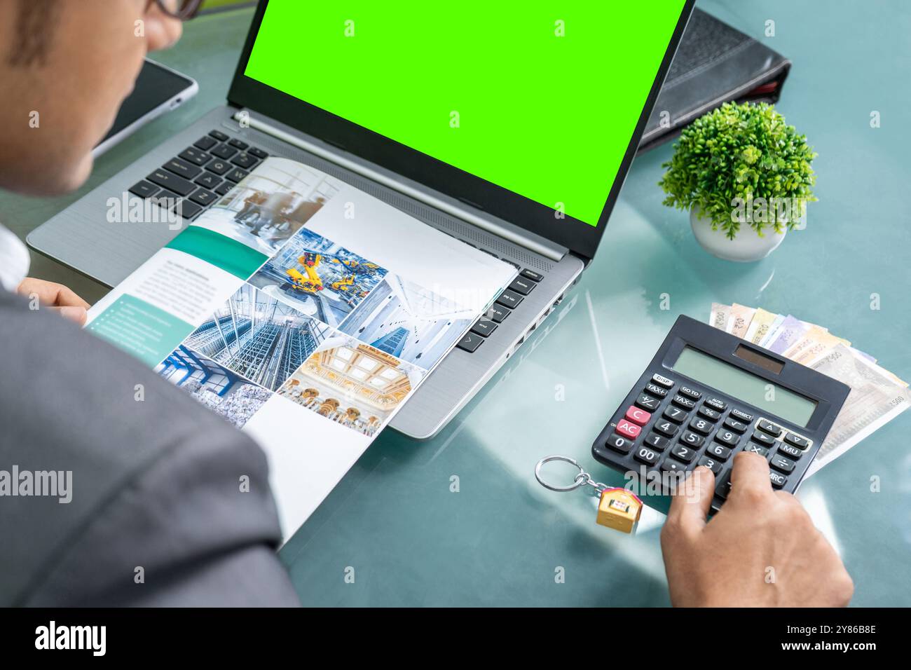 Garantire un prestito aziendale a basso interesse: Imprenditore in un ufficio moderno che si concentra sulla pianificazione finanziaria strategica e lavora diligentemente per garantire un basso tasso di interesse Foto Stock