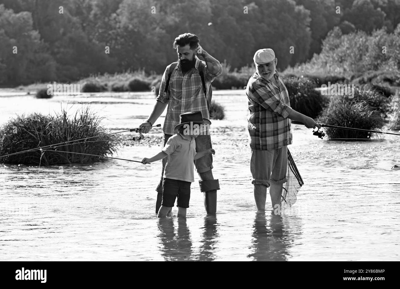 Hobby e attività sportive. Hobby uomo. Fine settimana estivo. Padre che insegna a figlio come pescare a mosca nel fiume. Giorno d'estate. Pescatori. Foto Stock