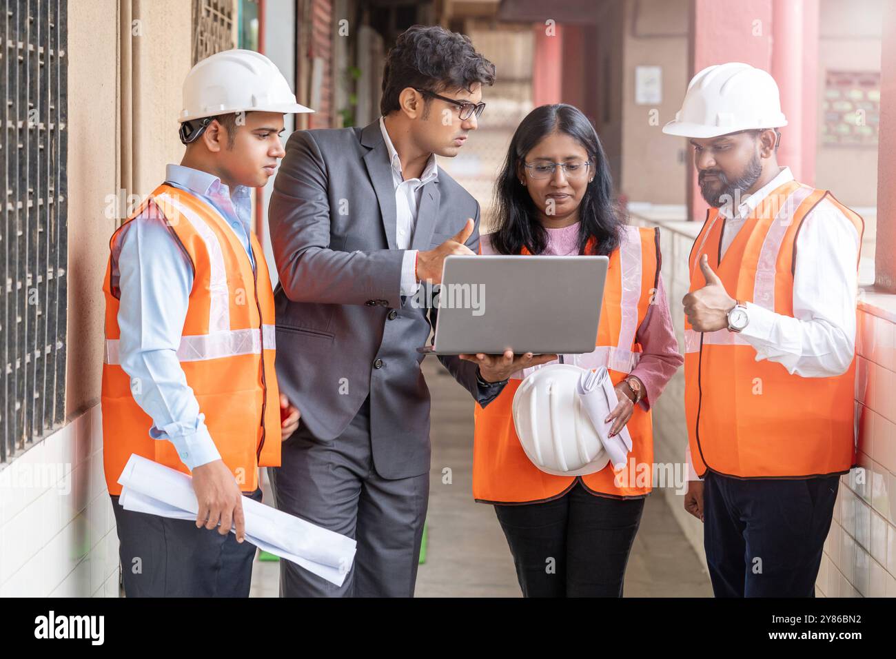 I professionisti del settore edile collaborano e discutono i requisiti del progetto presso il sito industriale lavoro di squadra in azione pianificazione del progetto, cantiere Foto Stock