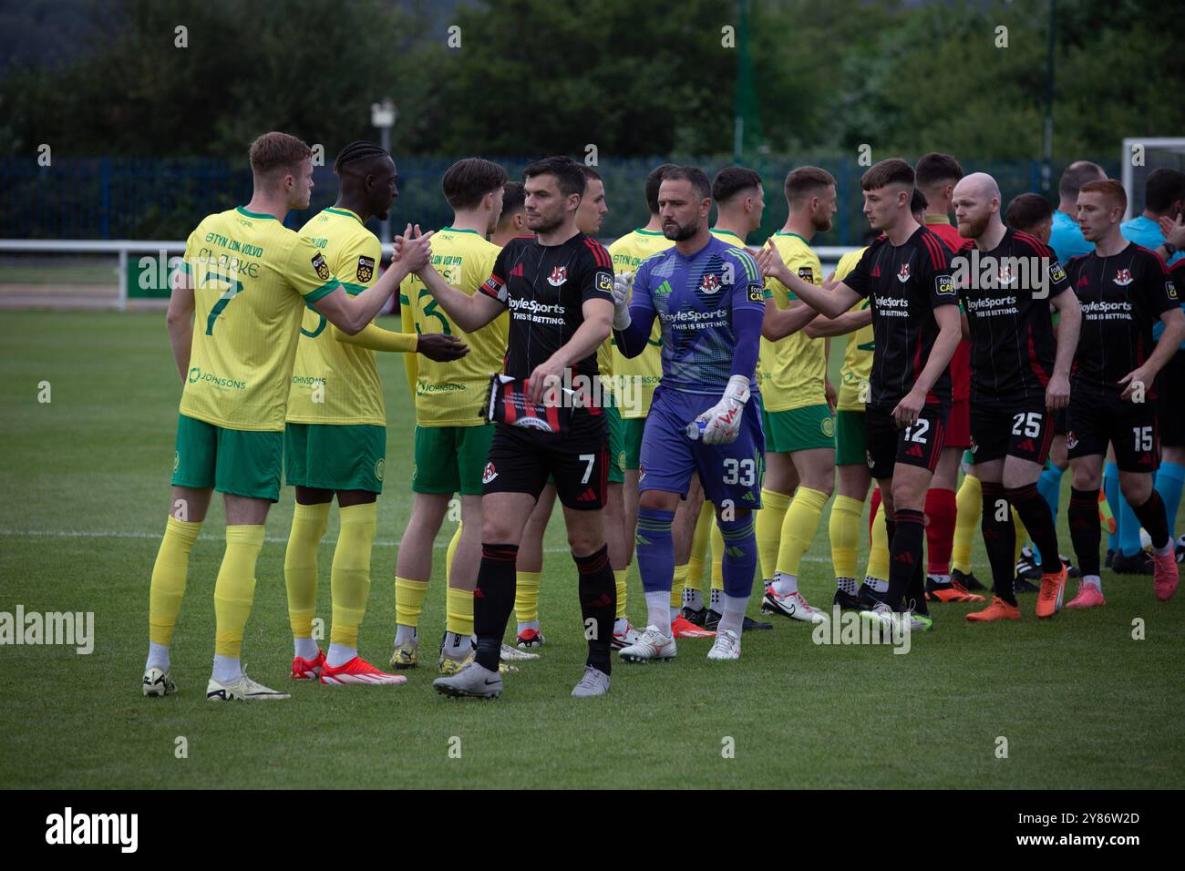 I giocatori che si scambiano strette di mano prima di Caernarfon Town (in giallo) giocano a Crusaders in un primo turno di qualificazione di Europa Conference, pareggio di andata, whic Foto Stock